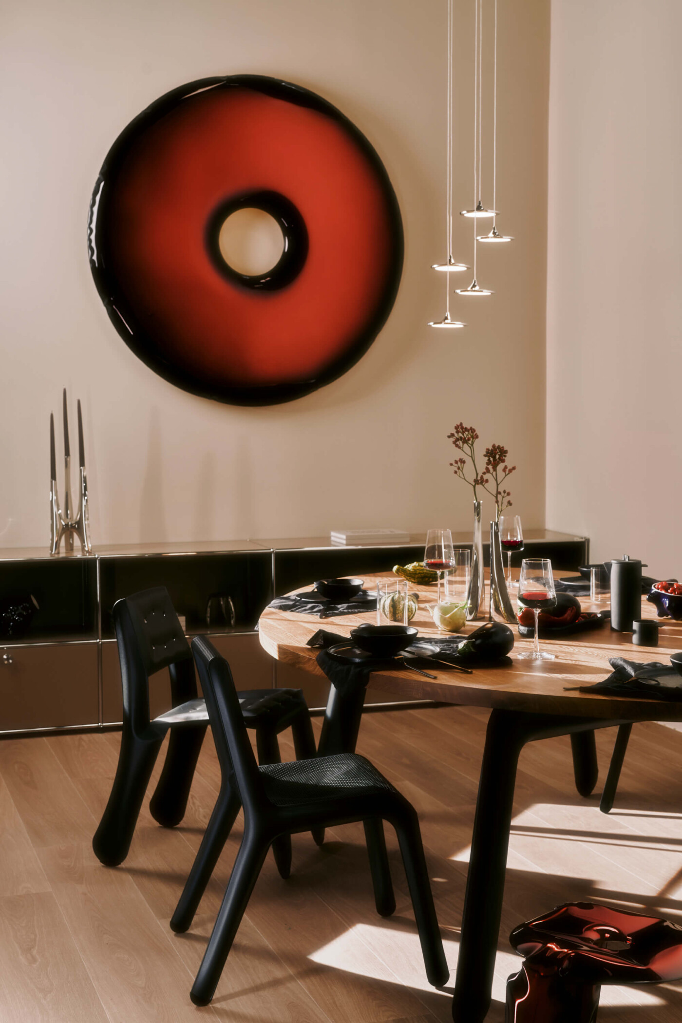 Zieta Studio, Rondo Mirror 120 w kolorze Red Rubin, Luna Lamps, Ultraleggera chair Black, Chippensteel Black, świecznik Triglav Inox, stół z nogami Black – nowoczesne wnętrze, design, lustro dekoracyjne, minimalistyczne oświetlenie, rzeźbiarskie meble, FiDU technology