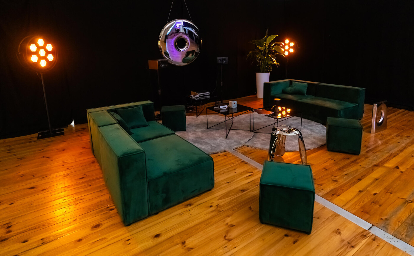 Zieta Studio’s Plopp stool and Rondo mirror made of polished inflated stainless steel in a modern living room setup.