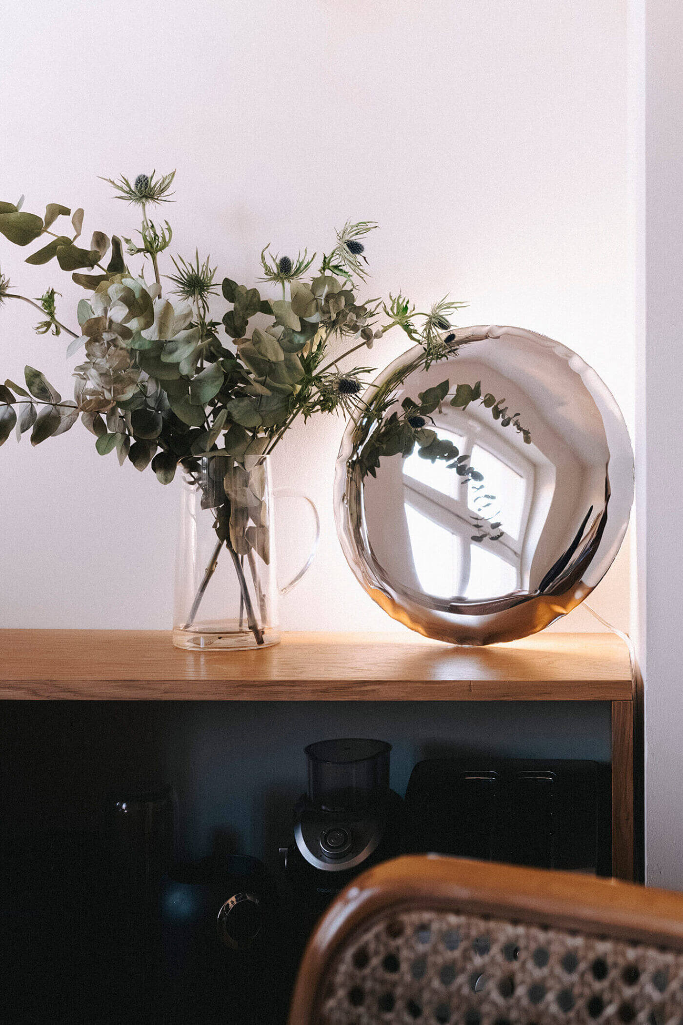 zieta kin wall lamp on a dresser next to a plant
