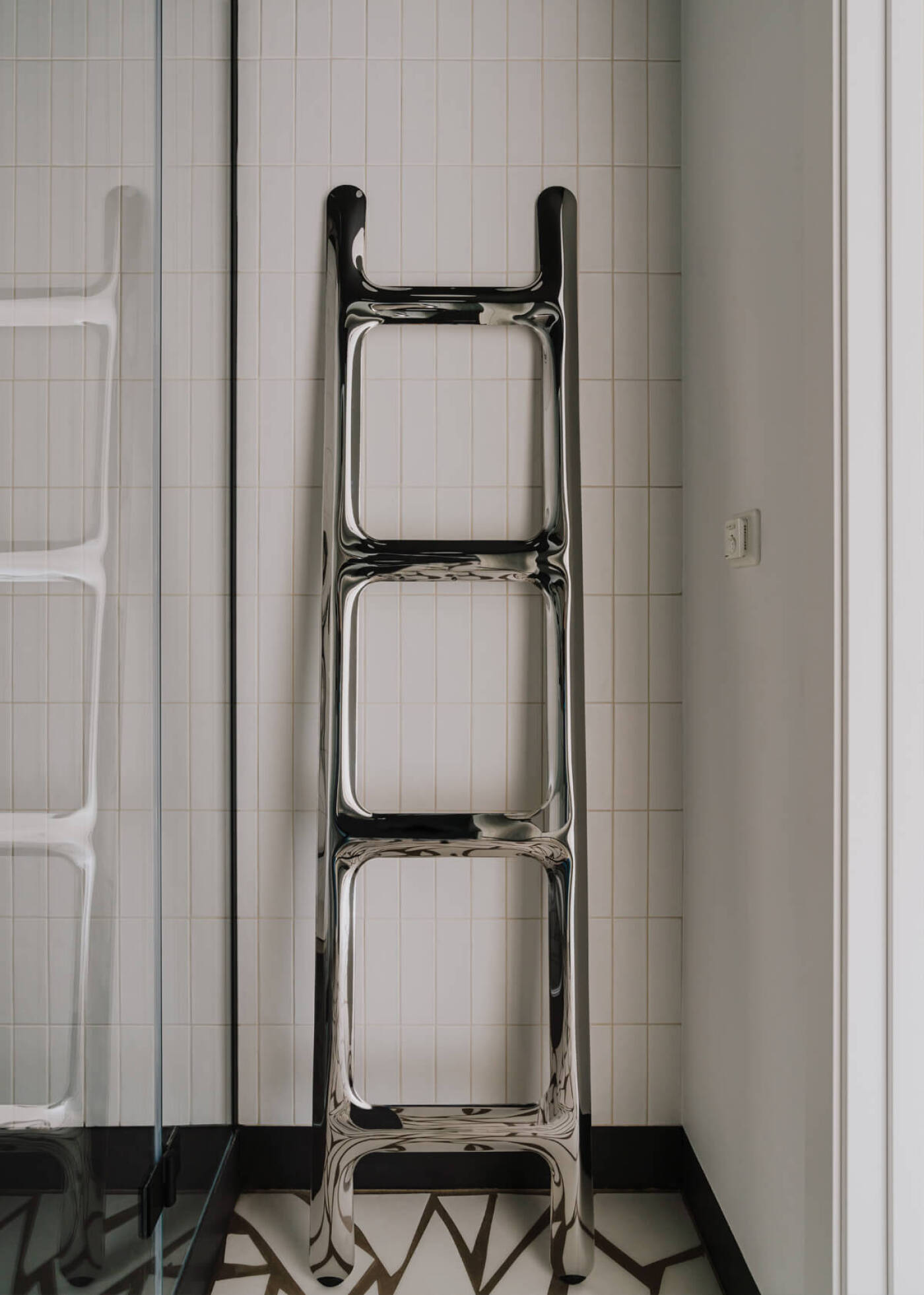 zieta drab hanger inox in a white tiled bathroom