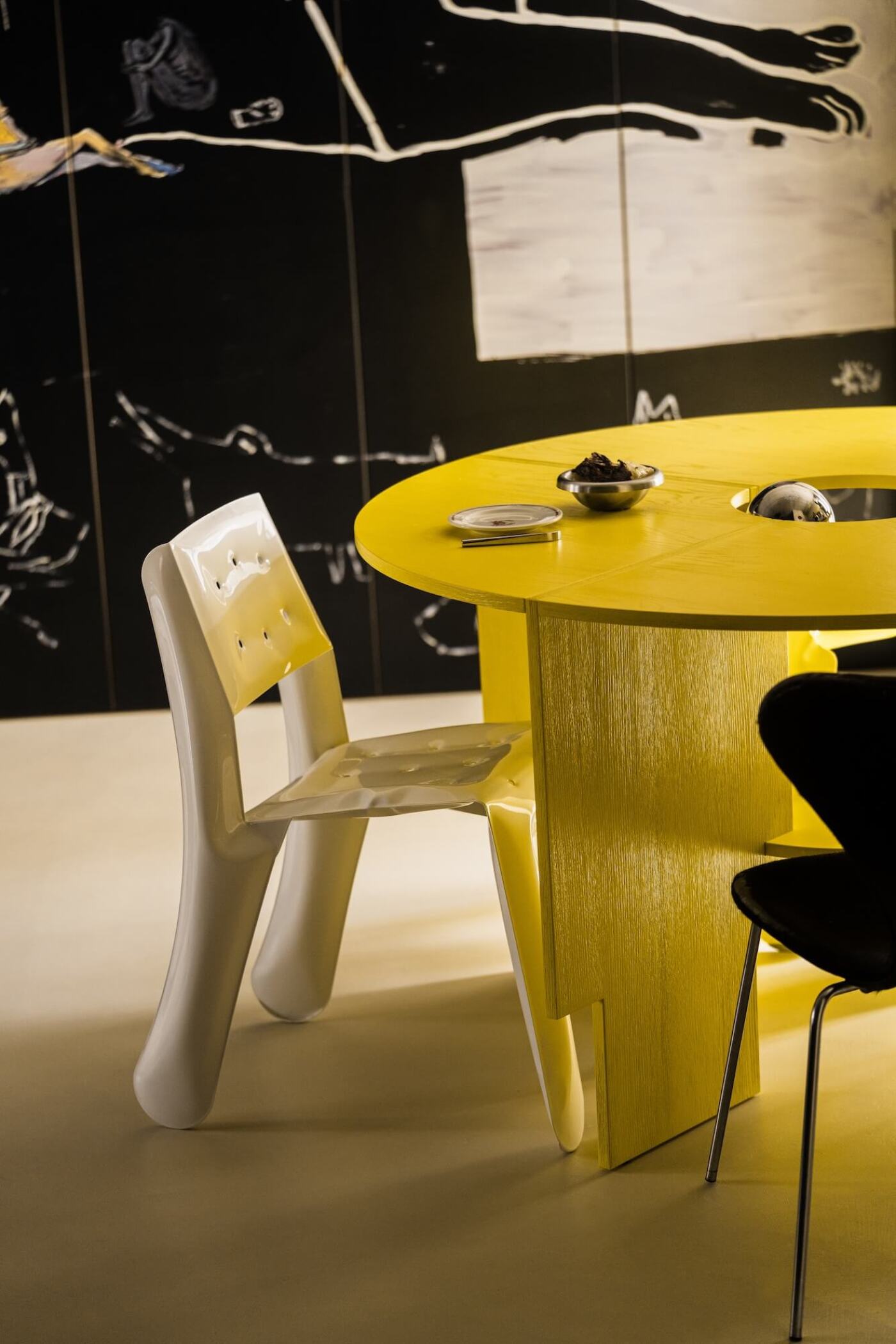 zieta white glossy chippensteel next to a bright yellow modern table