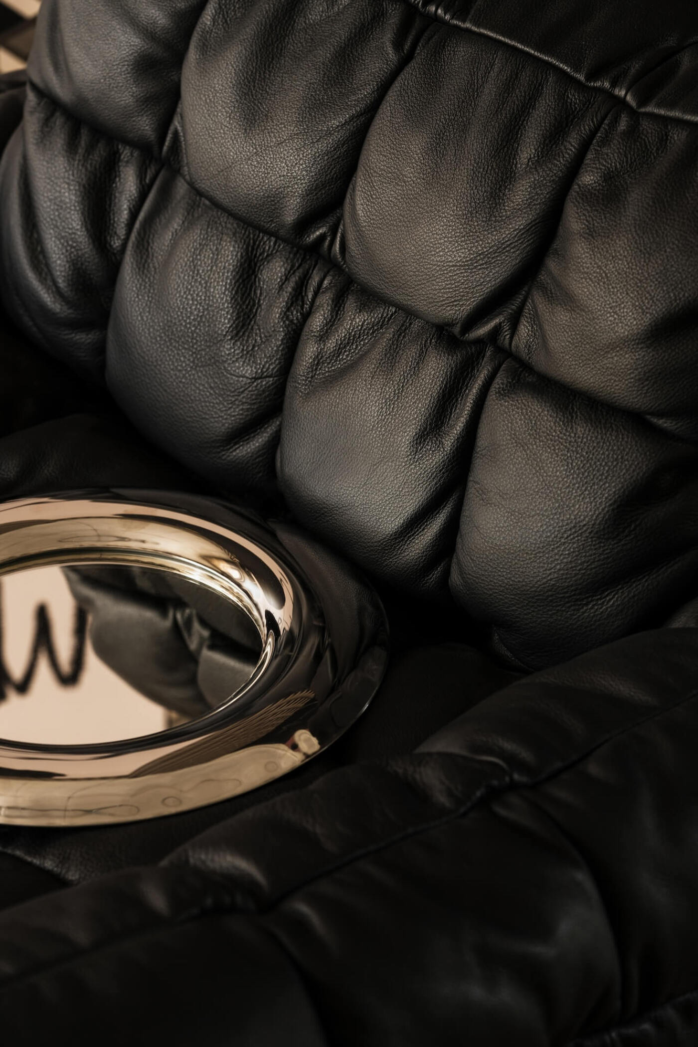 zieta rondel mirror laying on a leather couch