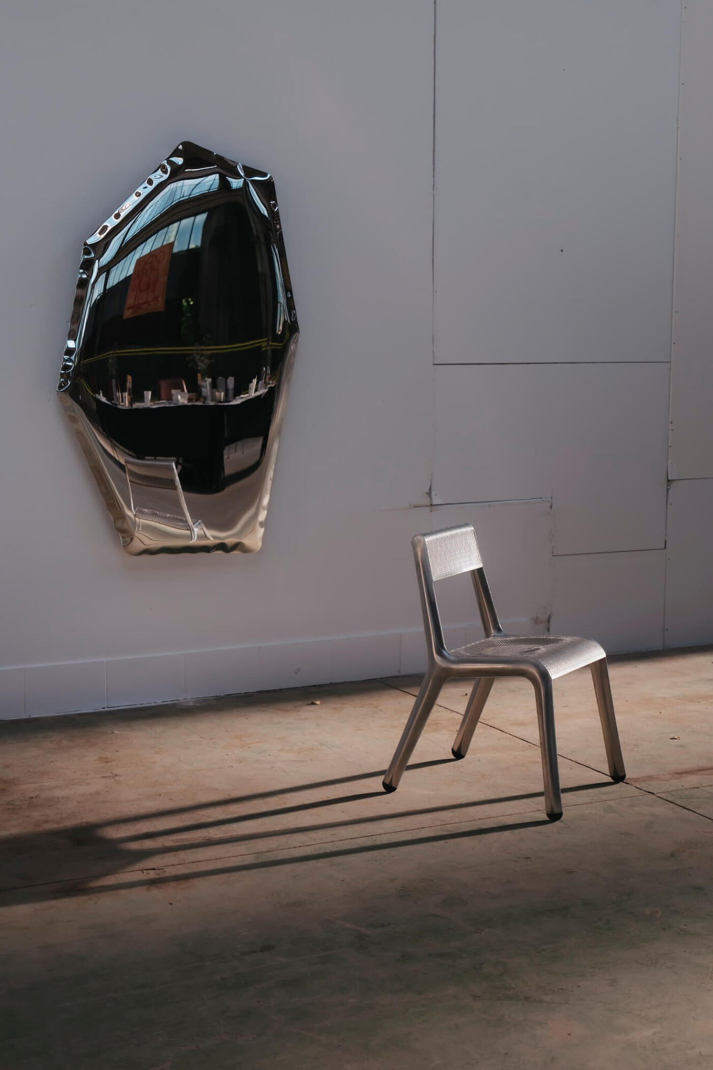 zieta tafla c mirror on a concrete wall next to the ultraleggera chair