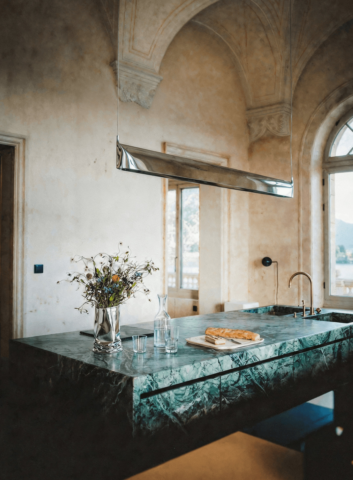 zieta blade lamp above natural stone kitchen island