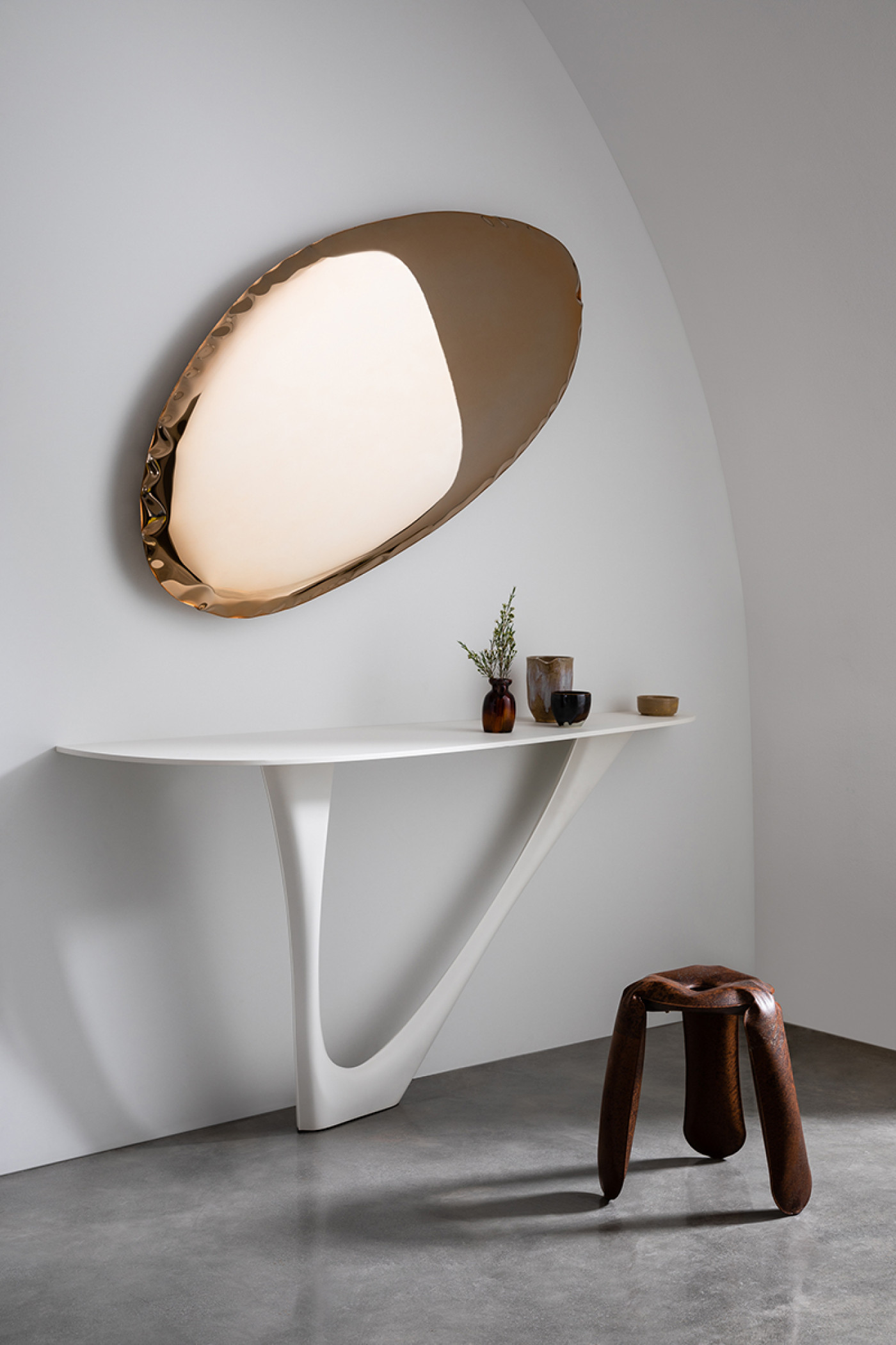Zieta Studio: Tafla O mirror rose gold, G-Console white matt, Plopp stool brown; sculptural elegance, soft reflections, modern minimalism, warm metallic tones, fluid forms, sophisticated interior, contemporary craftsmanship