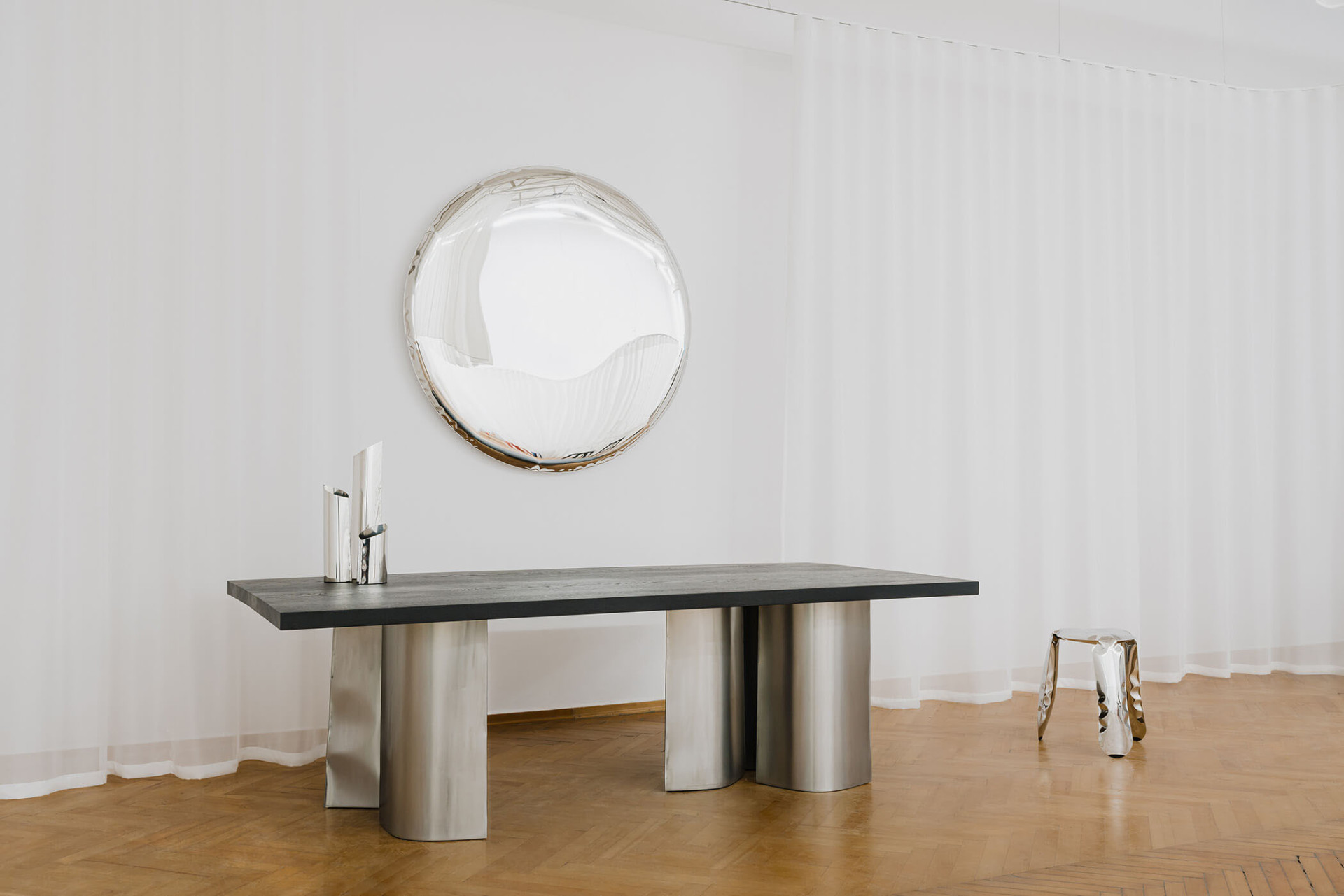 round shaped inflated steel mirror hanging on the wall in composition with parova table