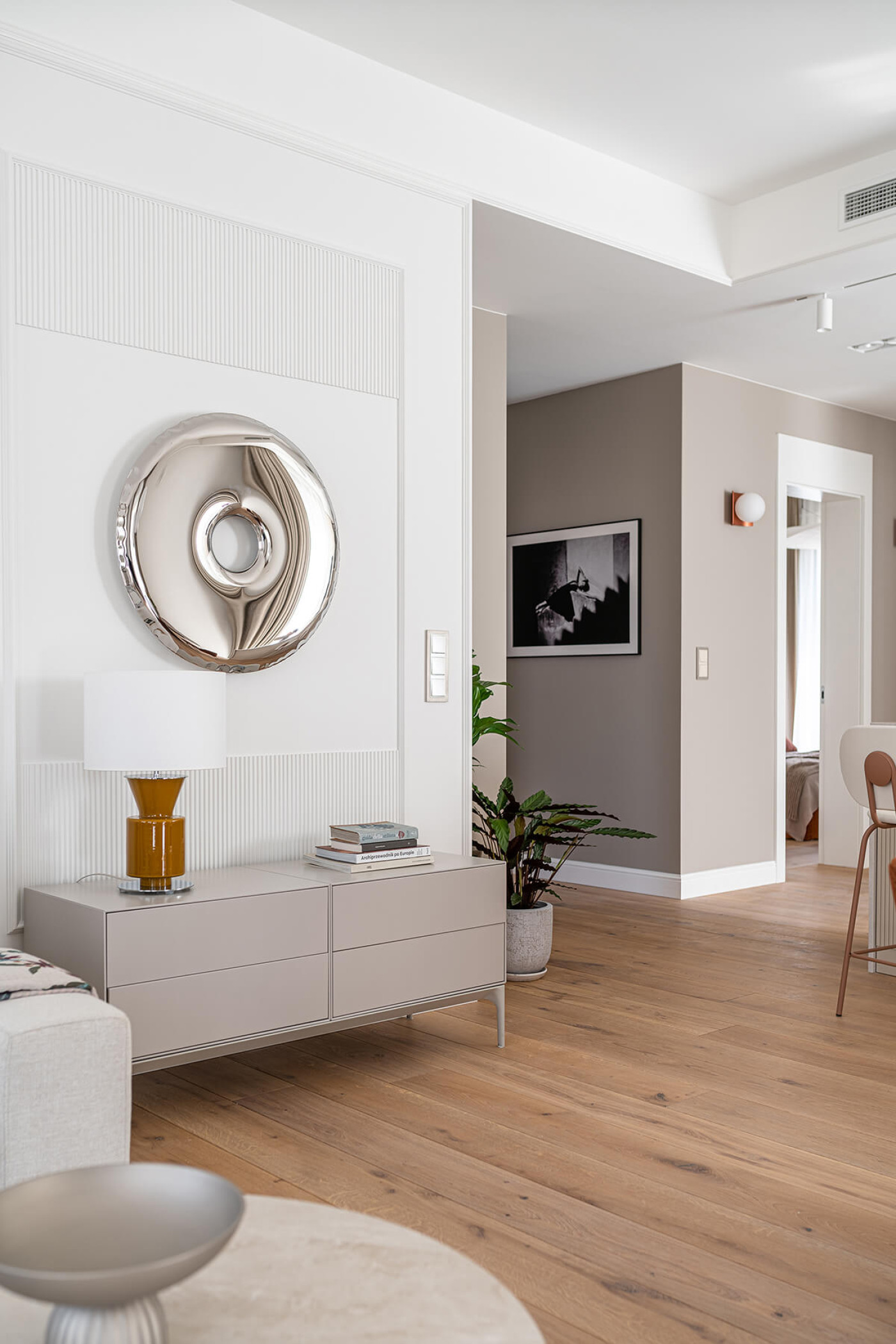 a donut shaped mirror in inox hanging on the wall 